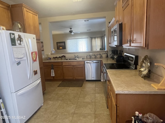15808 S Via Cayetano, Sahuarita, AZ 85629 - kitchen with stainless steel appliances, brown cabinets, a sink, and light countertops