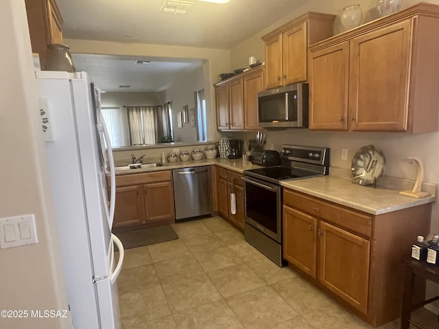 15808 S Via Cayetano, Sahuarita, AZ 85629 - kitchen with appliances with stainless steel finishes, a sink, light countertops, and brown cabinets