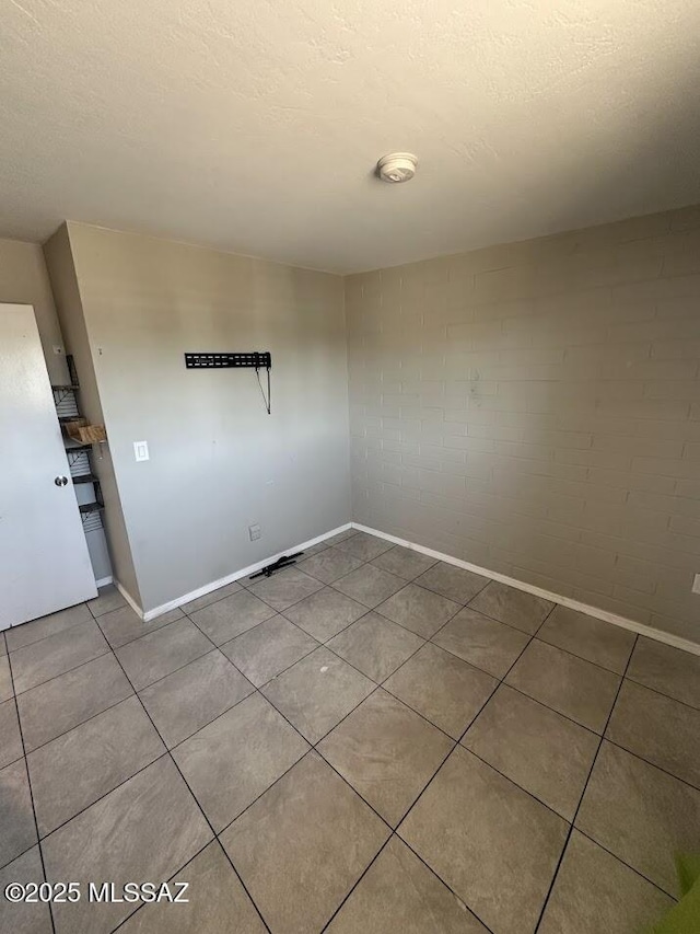 3958 N Pomona Rd, Tucson, AZ 85705 - empty room with baseboards, tile patterned flooring, and a textured ceiling