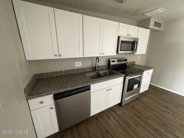 3958 N Pomona Rd, Tucson, AZ 85705 - kitchen with appliances with stainless steel finishes, a sink, dark wood-style flooring, and white cabinets