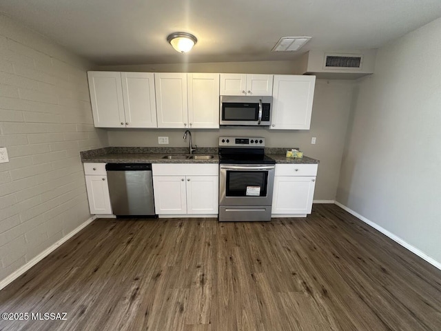 3958 N Pomona Rd, Tucson, AZ 85705 - kitchen featuring appliances with stainless steel finishes, a sink, baseboards, dark wood finished floors, and white cabinets