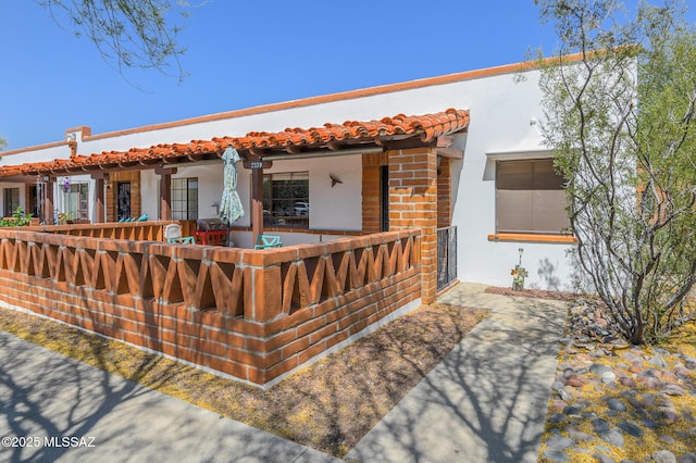 233 S Paseo Tierra Unit D, Green Valley, AZ 85614 - back of house with stucco siding, a porch, and a fenced front yard