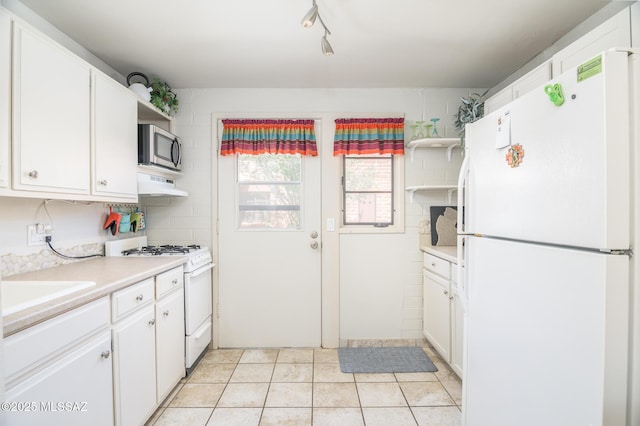 233 S Paseo Tierra Unit D, Green Valley, AZ 85614 - kitchen featuring white appliances, under cabinet range hood, light countertops, white cabinets, and a sink
