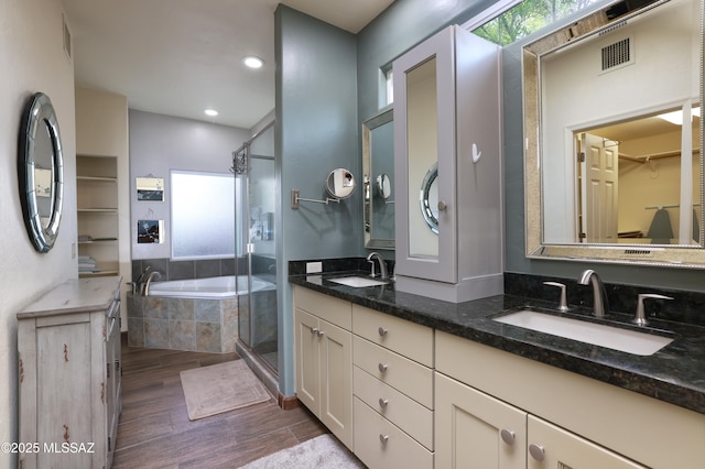 10550 N Lambert Pl, Tucson, AZ 85737 - bathroom with double vanity, a bath, wood finished floors, a stall shower, and a walk in closet
