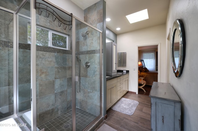 10550 N Lambert Pl, Tucson, AZ 85737 - bathroom featuring wood finished floors, vanity, a stall shower, a skylight, and recessed lighting