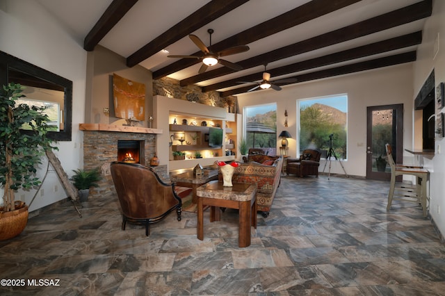 10550 N Lambert Pl, Tucson, AZ 85737 - living room featuring a ceiling fan, a fireplace, beam ceiling, and stone finish flooring