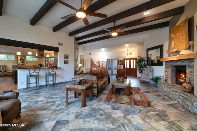 10550 N Lambert Pl, Tucson, AZ 85737 - living area with ceiling fan, a stone fireplace, beamed ceiling, and stone finish floors