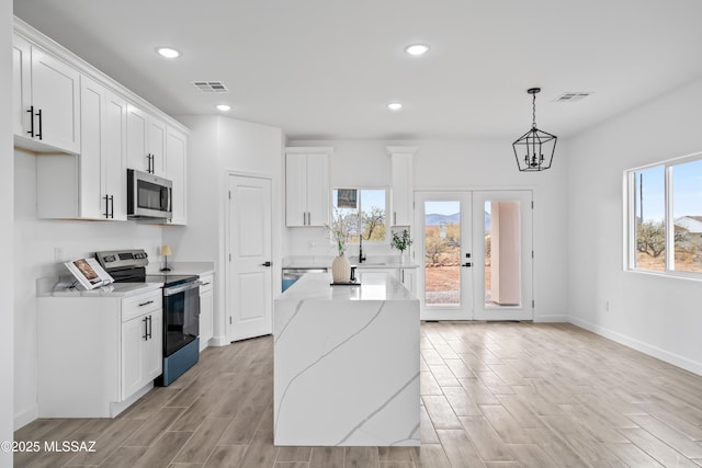 1917 Circulo Mexicali, Rio Rico, AZ 85648 - kitchen with appliances with stainless steel finishes, white cabinetry, recessed lighting, a kitchen island, and light wood-style floors