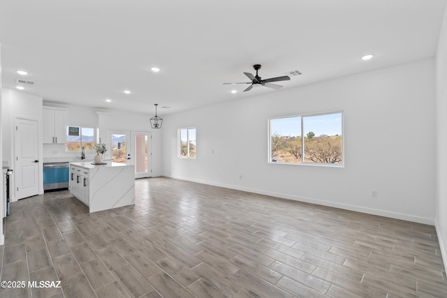 1917 Circulo Mexicali, Rio Rico, AZ 85648 - unfurnished living room featuring recessed lighting, a ceiling fan, light wood-type flooring, baseboards, and a sink
