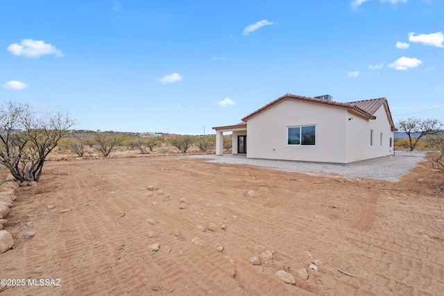 1917 Circulo Mexicali, Rio Rico, AZ 85648 - view of property exterior featuring stucco siding, a tiled roof, and dirt driveway