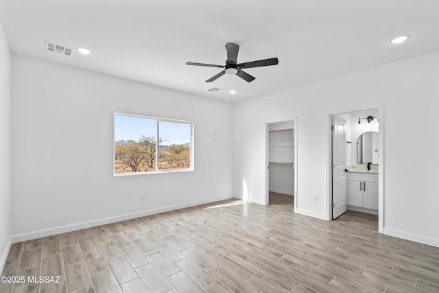1917 Circulo Mexicali, Rio Rico, AZ 85648 - unfurnished bedroom featuring light wood finished floors, a sink, a spacious closet, baseboards, and recessed lighting