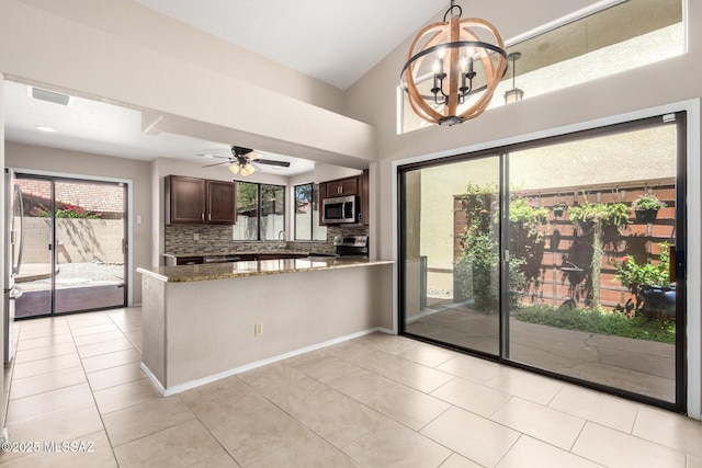 231 E Highcourte Ln, Tucson, AZ 85737 - kitchen with stainless steel appliances, plenty of natural light, a peninsula, light tile patterned floors, and a high ceiling