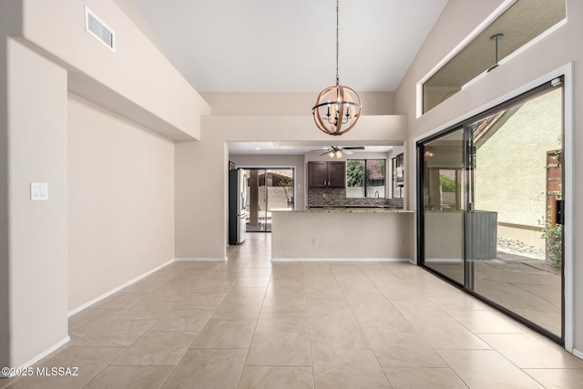 231 E Highcourte Ln, Tucson, AZ 85737 - spare room with a chandelier, light tile patterned floors, a ceiling fan, baseboards, and a towering ceiling