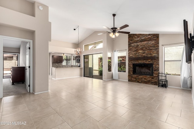 231 E Highcourte Ln, Tucson, AZ 85737 - unfurnished living room featuring ceiling fan, plenty of natural light, a fireplace, light tile patterned flooring, and high vaulted ceiling