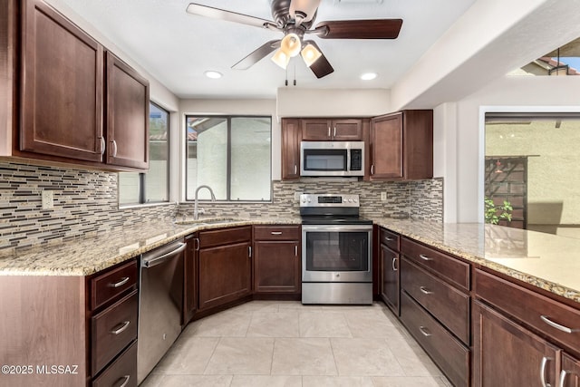 231 E Highcourte Ln, Tucson, AZ 85737 - kitchen featuring stainless steel appliances, a sink, a ceiling fan, and light stone countertops