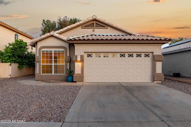 9102 N Safflower Ln, Tucson, AZ 85743 - mediterranean / spanish house with driveway, stucco siding, a garage, and a tiled roof