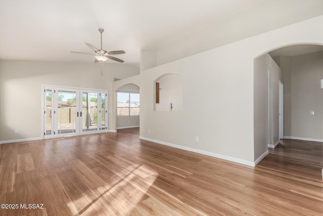 9102 N Safflower Ln, Tucson, AZ 85743 - unfurnished room with ceiling fan, baseboards, light wood-style flooring, arched walkways, and french doors