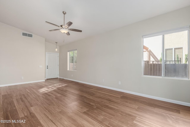 9102 N Safflower Ln, Tucson, AZ 85743 - unfurnished room with light wood-style flooring, a ceiling fan, vaulted ceiling, and baseboards