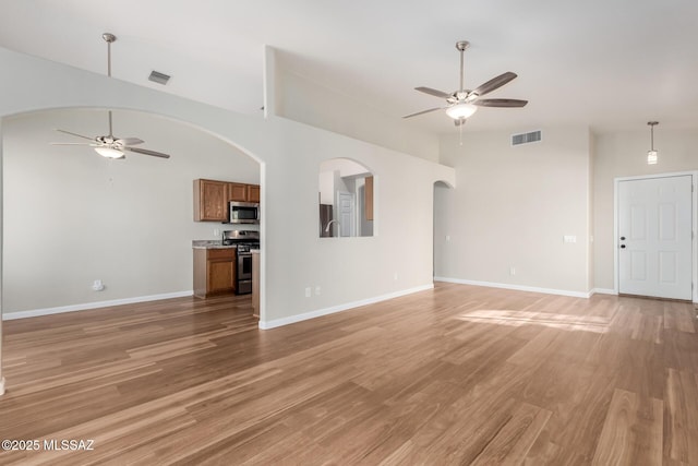 9102 N Safflower Ln, Tucson, AZ 85743 - unfurnished living room featuring ceiling fan, light wood-style floors, baseboards, and arched walkways