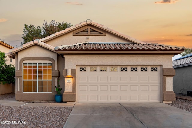 9102 N Safflower Ln, Tucson, AZ 85743 - mediterranean / spanish-style house with driveway, stucco siding, a garage, and a tiled roof