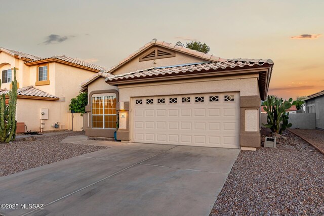 9102 N Safflower Ln, Tucson, AZ 85743 - mediterranean / spanish home with driveway, stucco siding, an attached garage, and a tiled roof