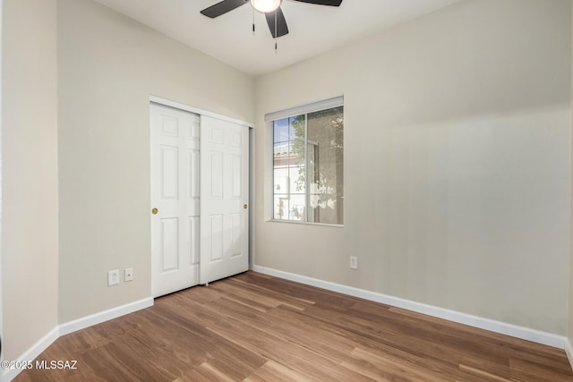 9102 N Safflower Ln, Tucson, AZ 85743 - unfurnished bedroom featuring wood finished floors, baseboards, and a closet