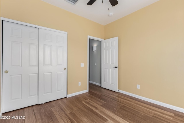 9102 N Safflower Ln, Tucson, AZ 85743 - unfurnished bedroom with wood finished floors, baseboards, a closet, and ceiling fan