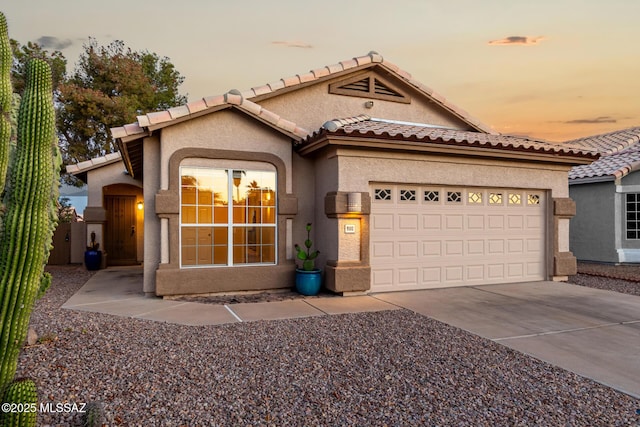 9102 N Safflower Ln, Tucson, AZ 85743 - mediterranean / spanish home with stucco siding, driveway, an attached garage, and a tiled roof