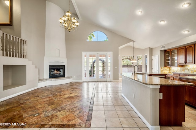 11562 N Scioto Ave, Tucson, AZ 85737 - kitchen featuring a chandelier, a sink, baseboards, glass insert cabinets, and high vaulted ceiling
