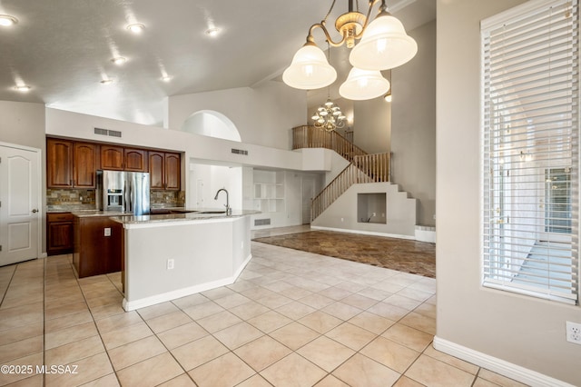 11562 N Scioto Ave, Tucson, AZ 85737 - kitchen featuring stainless steel refrigerator with ice dispenser, a chandelier, light tile patterned floors, high vaulted ceiling, and decorative backsplash