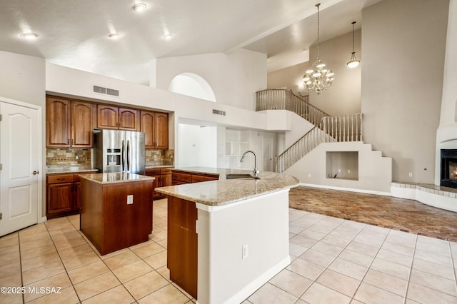 11562 N Scioto Ave, Tucson, AZ 85737 - kitchen featuring a large island, stainless steel fridge with ice dispenser, a sink, light tile patterned flooring, and tasteful backsplash