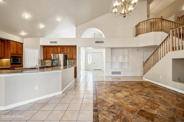 11562 N Scioto Ave, Tucson, AZ 85737 - kitchen featuring appliances with stainless steel finishes, high vaulted ceiling, brown cabinetry, open floor plan, and a sink