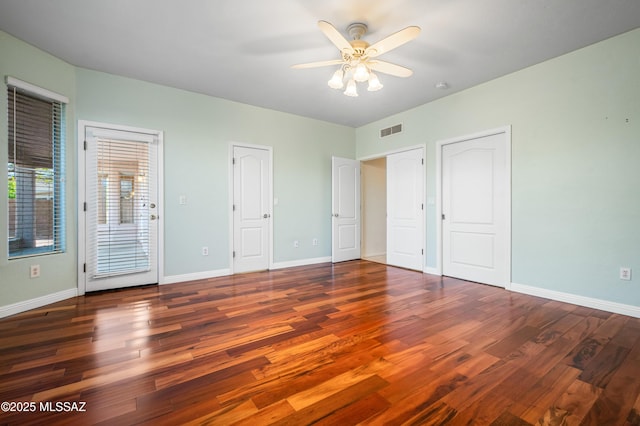 11562 N Scioto Ave, Tucson, AZ 85737 - unfurnished bedroom with wood finished floors, baseboards, and two closets