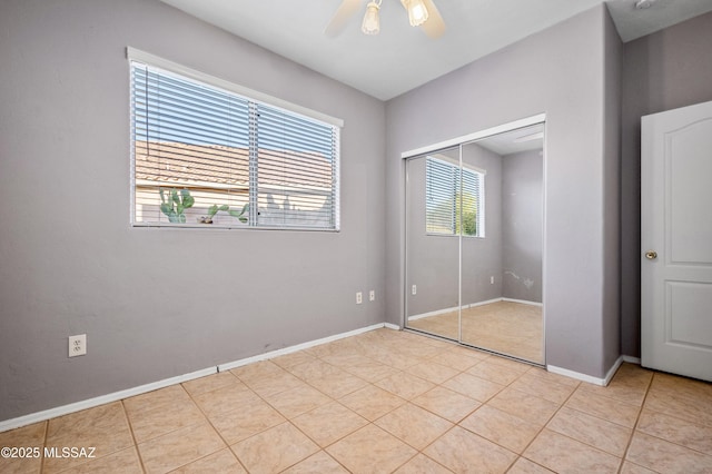 11562 N Scioto Ave, Tucson, AZ 85737 - unfurnished bedroom featuring a closet, light tile patterned floors, baseboards, and ceiling fan