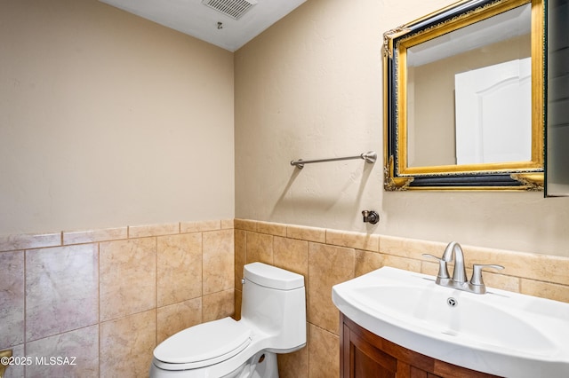 11562 N Scioto Ave, Tucson, AZ 85737 - bathroom with tile walls, toilet, vanity, and a wainscoted wall