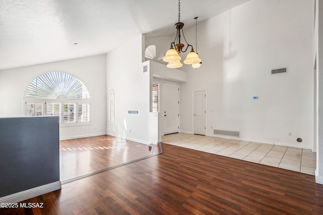 11562 N Scioto Ave, Tucson, AZ 85737 - entryway featuring wood finished floors, a chandelier, high vaulted ceiling, and baseboards