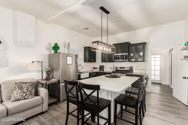 118 N Hoff Ave, Tucson, AZ 85705 - kitchen featuring appliances with stainless steel finishes, light countertops, tasteful backsplash, and light wood-style flooring