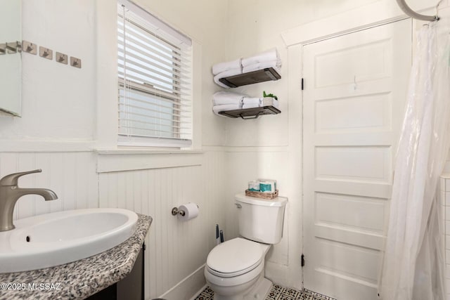 118 N Hoff Ave, Tucson, AZ 85705 - full bath featuring a wainscoted wall, a sink, toilet, and a shower with curtain