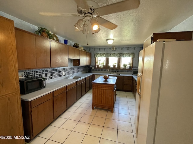 11985 N Cayce Ln, Casa Grande, AZ 85194 - kitchen featuring black microwave, freestanding refrigerator, a sink, a center island, and light tile patterned flooring