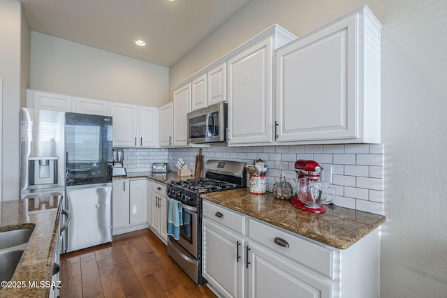 983 N Via Zahara Del Sol, Tucson, AZ 85748 - kitchen with appliances with stainless steel finishes, decorative backsplash, white cabinetry, dark wood-style flooring, and dark stone countertops