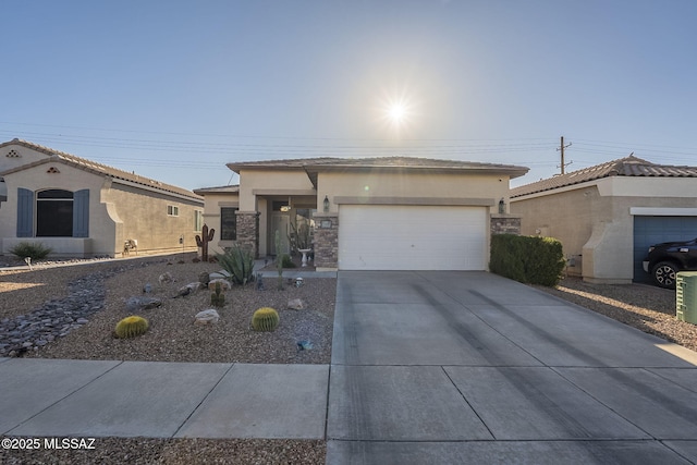 983 N Via Zahara Del Sol, Tucson, AZ 85748 - view of front of house featuring a garage, concrete driveway, stucco siding, and stone siding