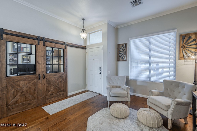 983 N Via Zahara Del Sol, Tucson, AZ 85748 - living area featuring a barn door, hardwood / wood-style flooring, crown molding, and baseboards
