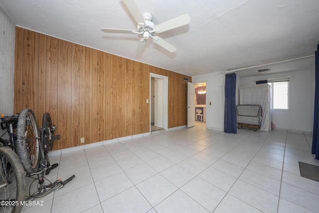 3431 N Edith Blvd, Tucson, AZ 85716 - unfurnished living room with wood walls, ceiling fan, light tile patterned floors, and baseboards