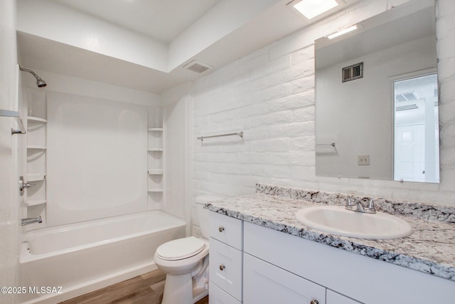 8450 E Old Spanish Trl Unit 157, Tucson, AZ 85710 - bathroom featuring vanity, washtub / shower combination, wood finished floors, and toilet