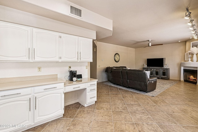 1920 W Canada Hills Dr, Oro Valley, AZ 85737 - living area with ceiling fan, rail lighting, and a lit fireplace
