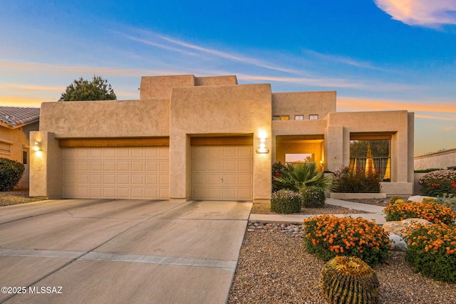 1920 W Canada Hills Dr, Oro Valley, AZ 85737 - pueblo revival-style home featuring an attached garage, stucco siding, and concrete driveway