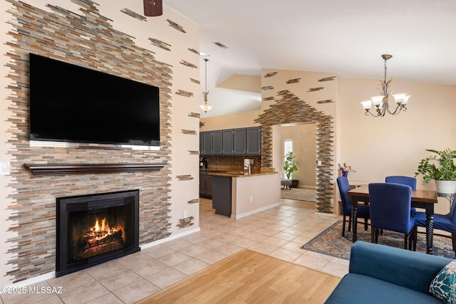 9141 E Bell Cactus Ln, Tucson, AZ 85715 - living area featuring a chandelier, light tile patterned floors, a glass covered fireplace, and high vaulted ceiling