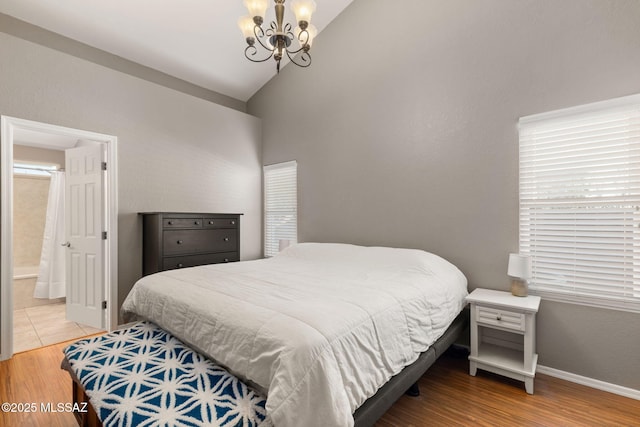 9141 E Bell Cactus Ln, Tucson, AZ 85715 - bedroom featuring a chandelier, vaulted ceiling, light wood-style flooring, ensuite bathroom, and baseboards