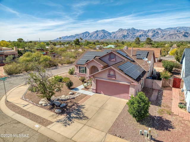 9141 E Bell Cactus Ln, Tucson, AZ 85715 - view of front of house with stucco siding, concrete driveway, roof mounted solar panels, a gate, and a mountain view