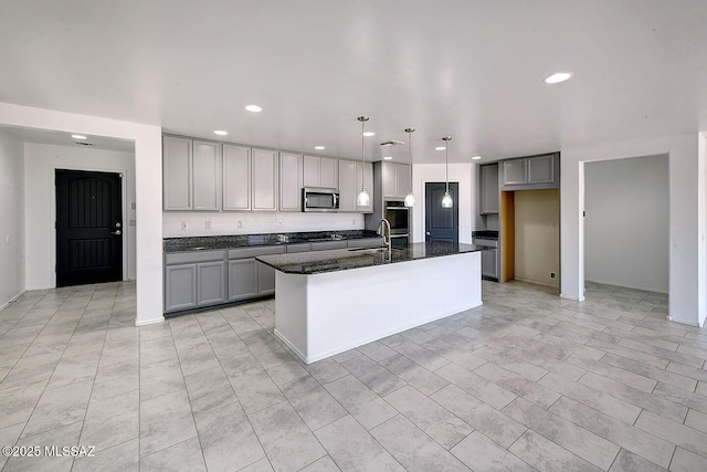 11710 W Boll Bloom Dr, Marana, AZ 85653 - kitchen with gray cabinets, stainless steel microwave, recessed lighting, dark stone countertops, and a center island with sink